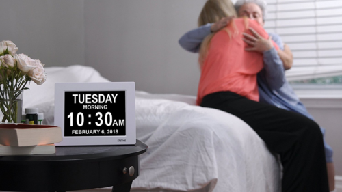 A man and woman laying in bed smiling for the camera.