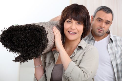 A man and woman laying in bed smiling for the camera.