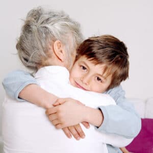 A young boy hugging an older woman.