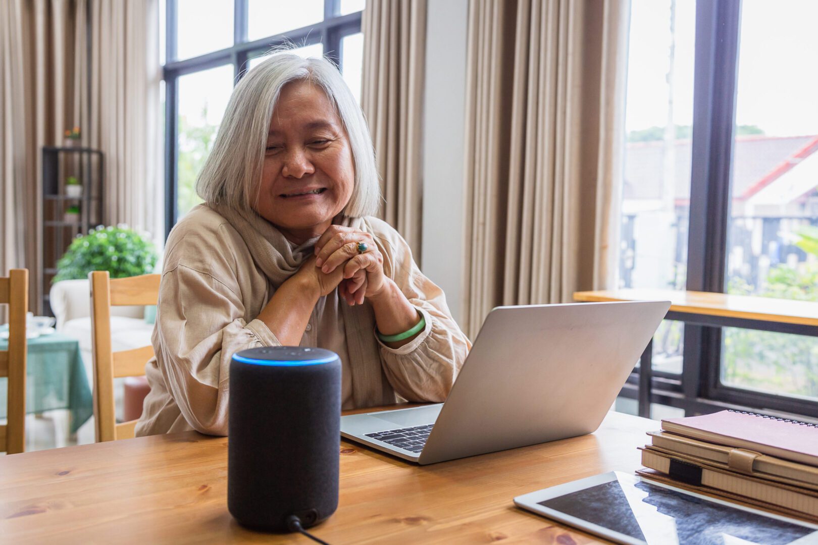 Elderly woman smiling at smart speaker
