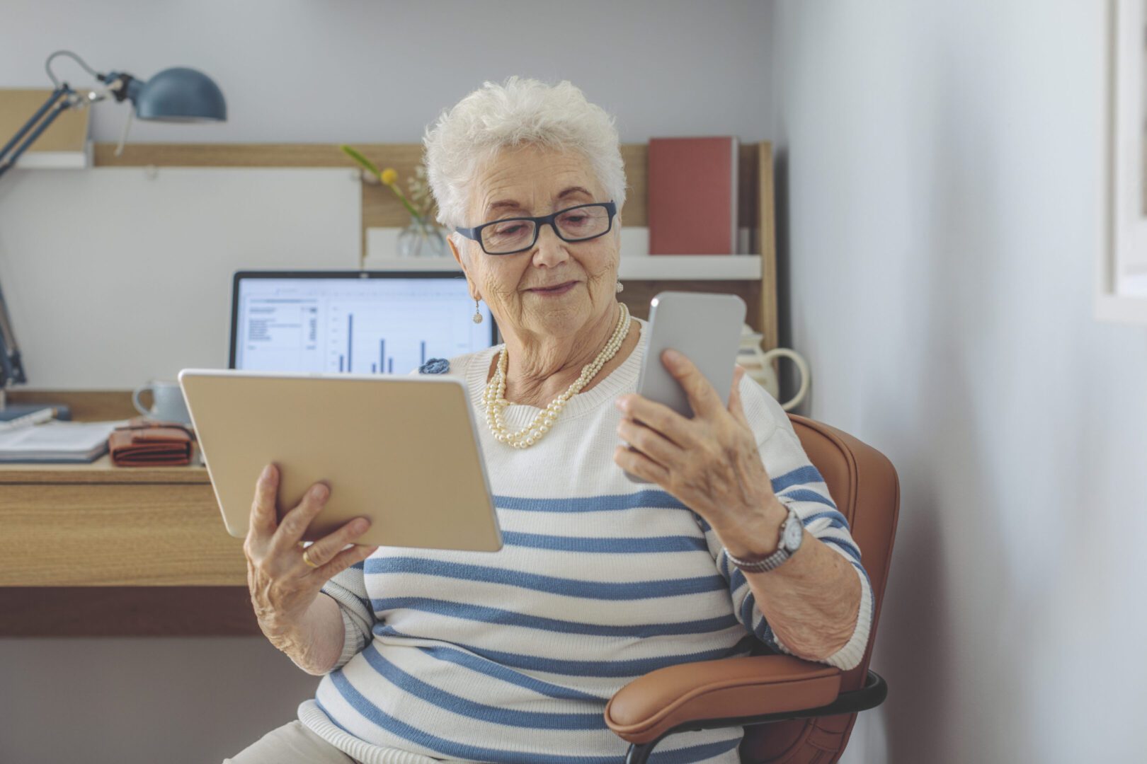 Elderly woman using tablet and smartphone